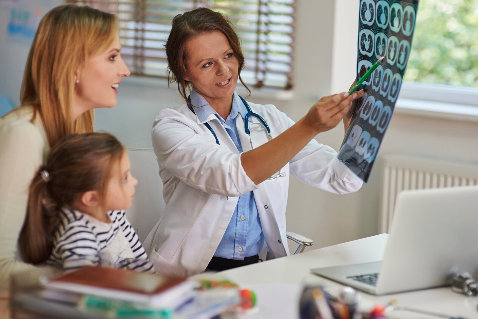 A spacious medical examination room, brightly lit by overhead skylights. In the foreground, a young patient stands upright, clad in a simple hospital gown, their back exposed for a thorough scoliosis screening. A concerned medical professional, dressed in a pristine white coat, carefully examines the patient's spine, using gentle hands to trace the contours and identify any abnormalities. The background features essential medical equipment, like an adjustable exam table and a wall-mounted display showcasing an X-ray image, providing a sense of the clinical setting. The overall atmosphere conveys a sense of attentiveness and care, as the healthcare provider works diligently to detect early signs of spinal curvature, ensuring prompt intervention and the patient's well-being.