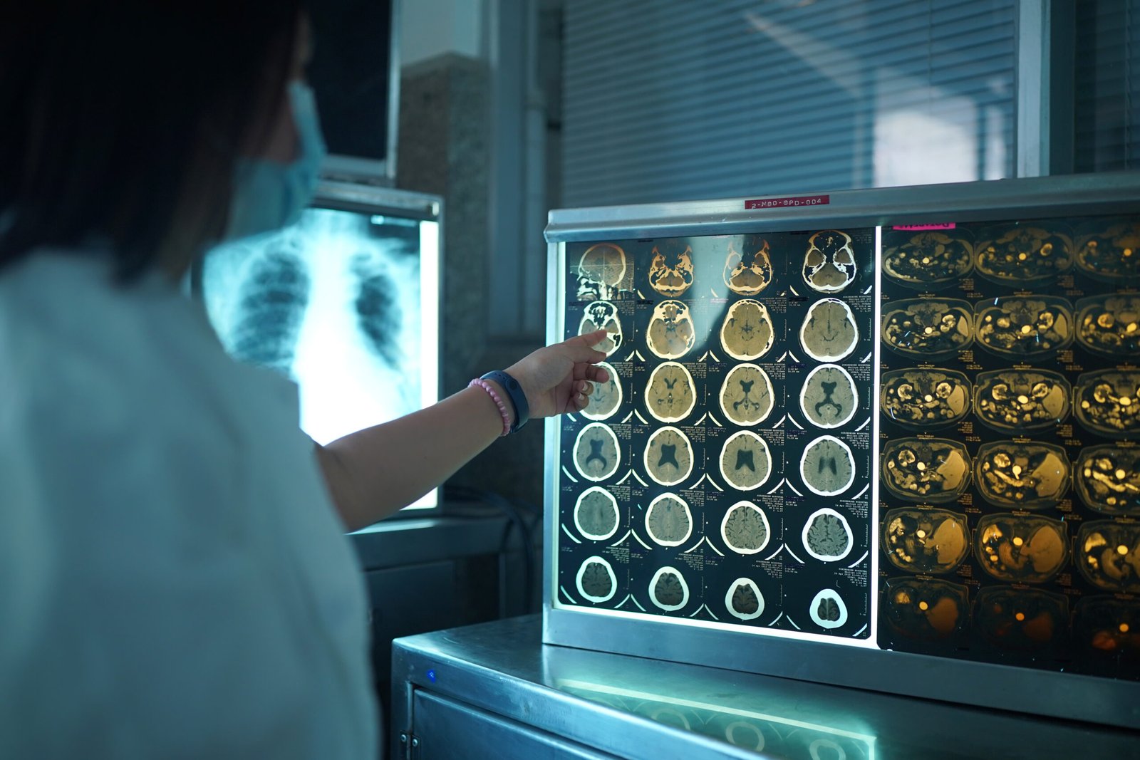 Detailed medical imaging laboratory, bathed in warm lighting. In the foreground, a radiologist reviewing a series of high-resolution scans on a large, state-of-the-art display. Surrounding them, advanced diagnostic equipment and workstations, symbolizing the technological capabilities of remote radiology services. In the background, a panoramic view of a modern, interconnected medical facility, highlighting the integrated nature of teleradiology. Convey a sense of expertise, efficiency, and the seamless delivery of specialized radiology services from a distance.
